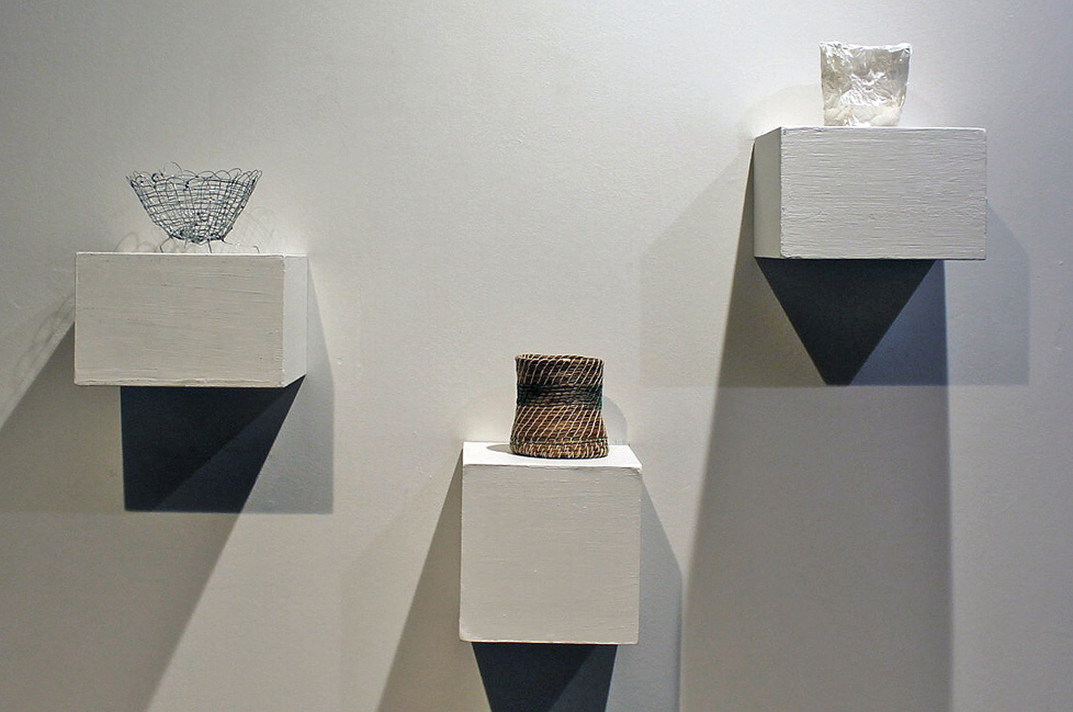 three small vessels on wall pedestals