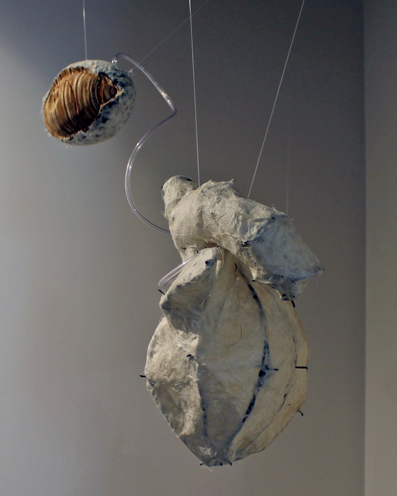 hanging sculpture: wooden eyeball wit tube to paper heart