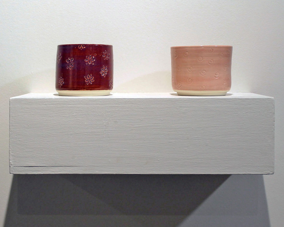two ceramic jars on a shelf