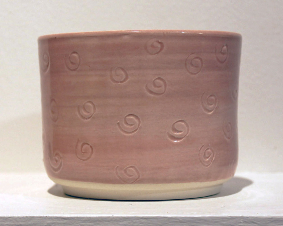 pink cylindrical jar with swirl pattern