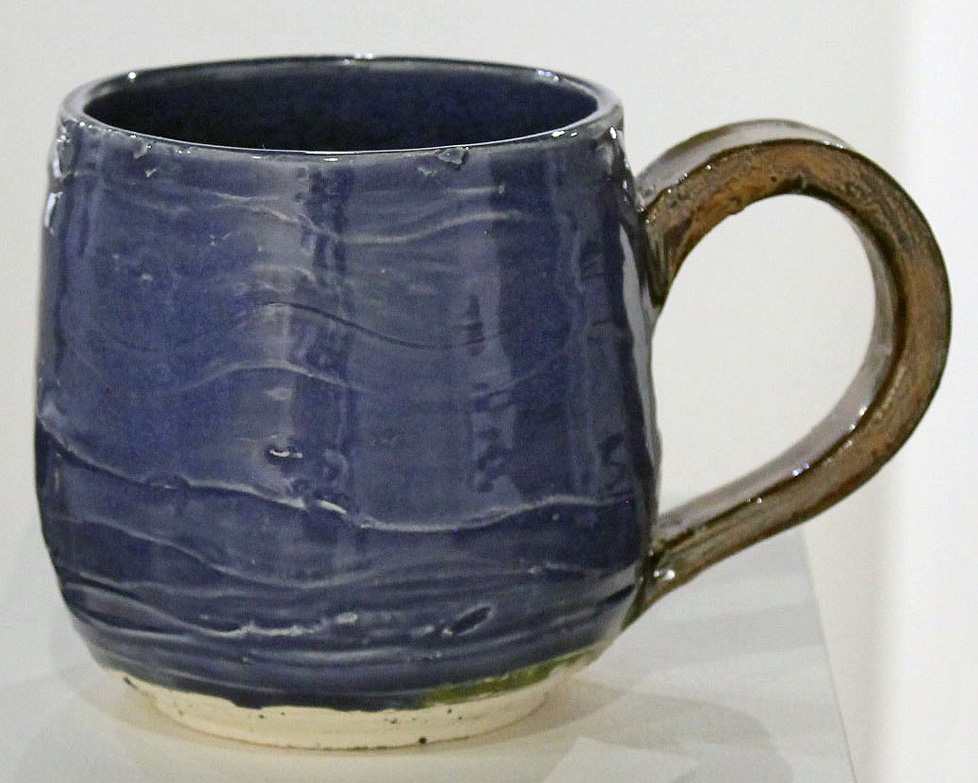 blue ceramic mug with wavy texture and brown handle