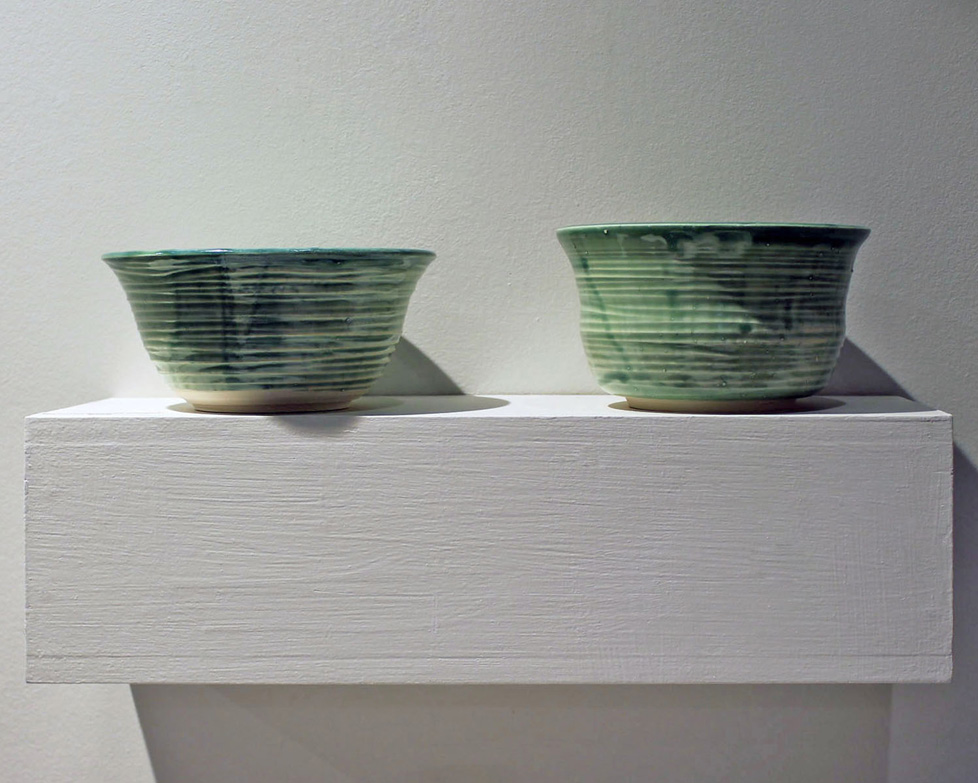 2 spearmint green bowls on a shelf