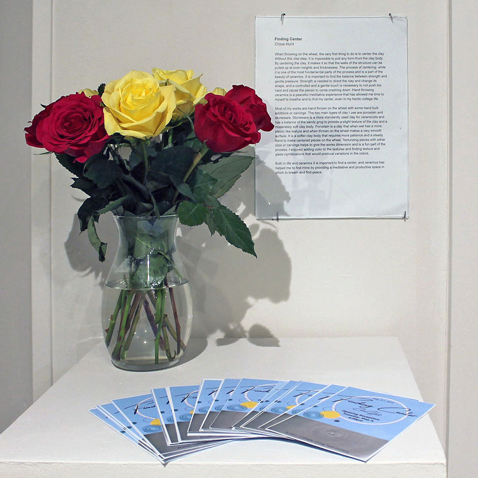 vase with red and yellow roses, artist statement, and invitations