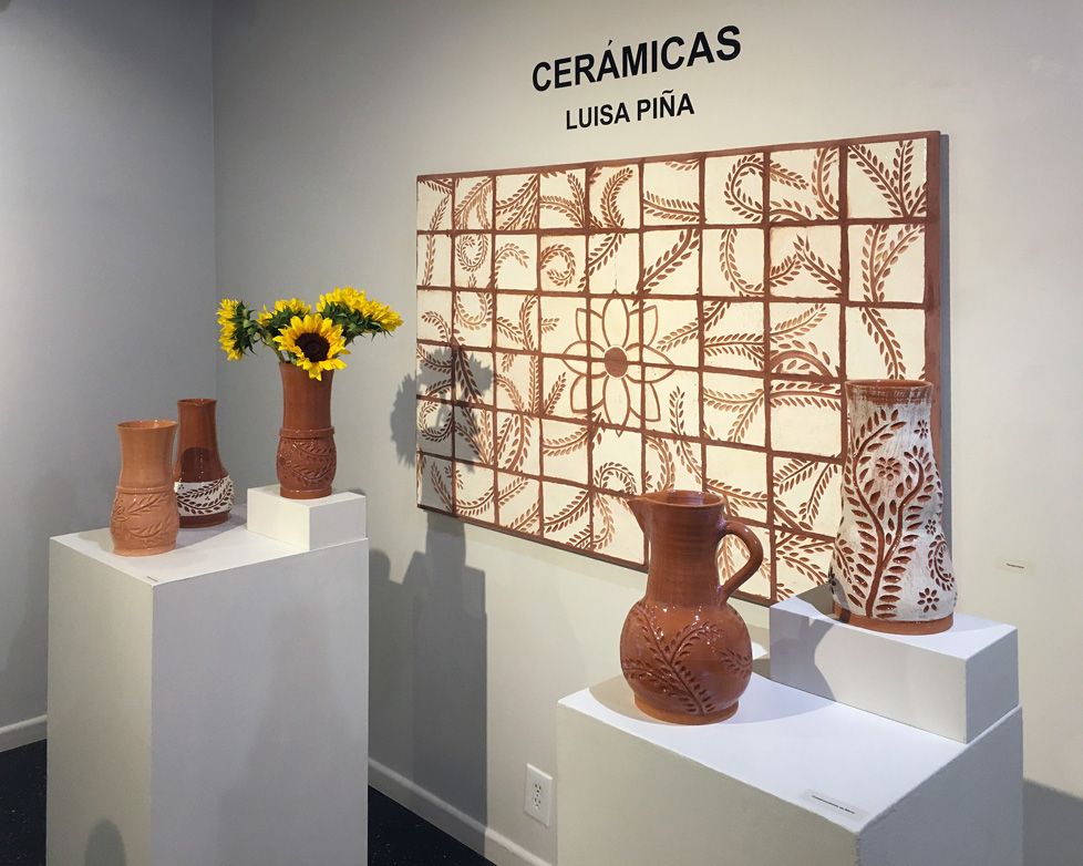 installation view of tile mural and several vessels