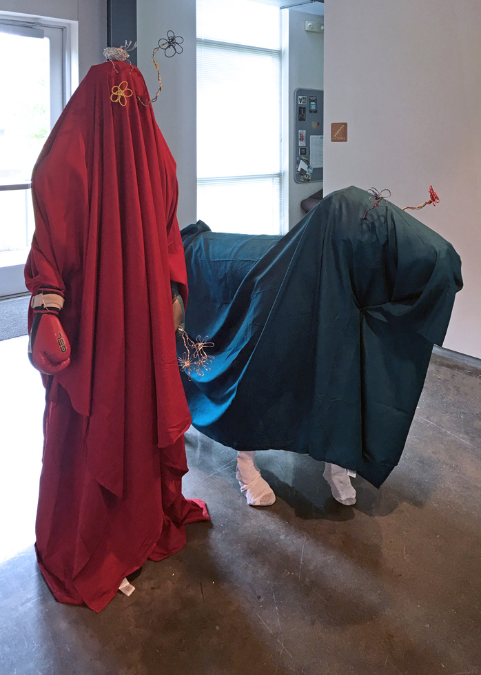 life-size human form and animal form both covered with draping fabric