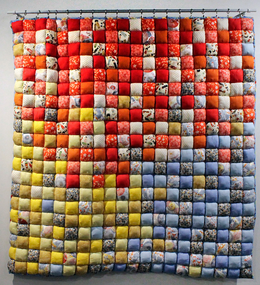 quilt of pixelated blues, yellows, and reds