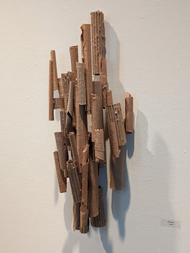 wall-hanging sculpture of cardboard tubes