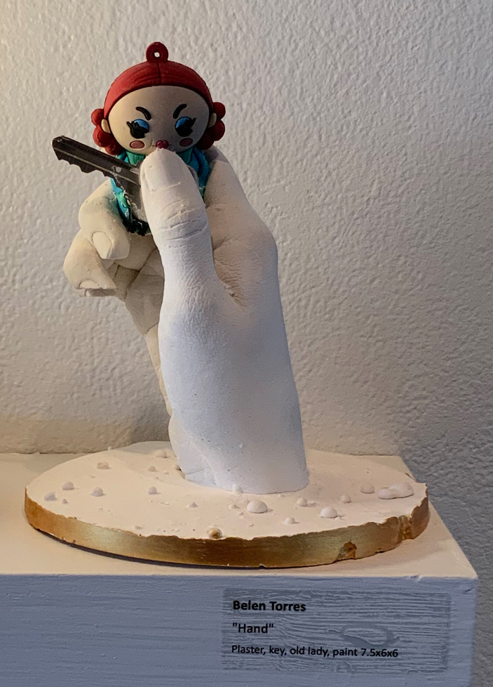 plaster hand holding figurine