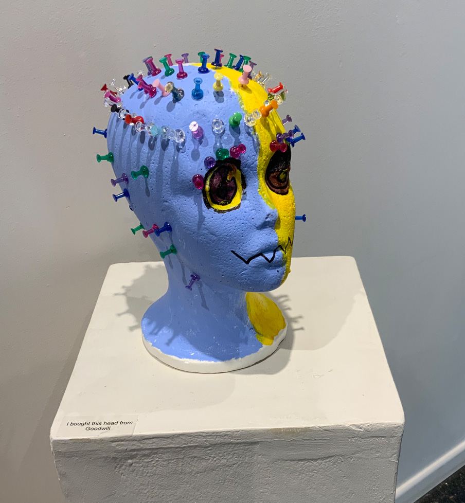 foam head painted half blue and half yellow with pushpins