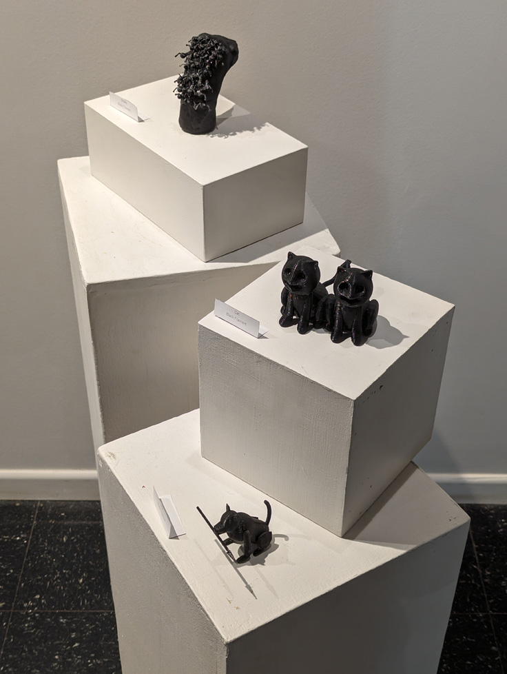 collection of small 3D printed animal figures in black filament