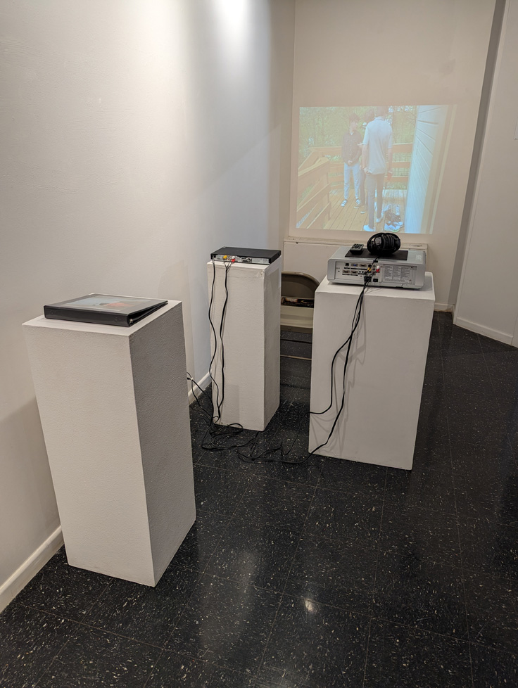 view of gallery with projection equipment and photo binder on pedestals