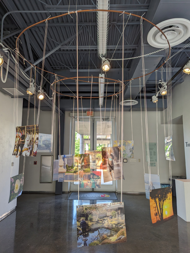 metal ring hanging from ceiling with photos hanging from string