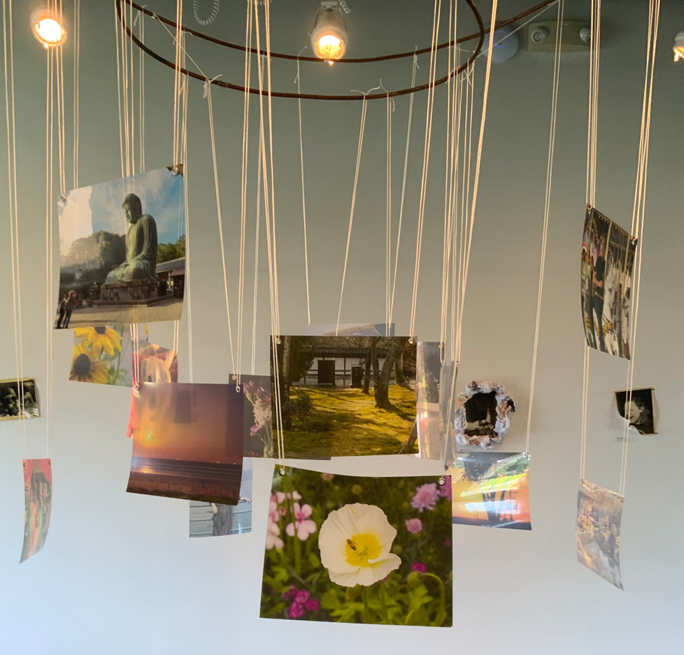 metal ring hanging from ceiling with photos hanging from string