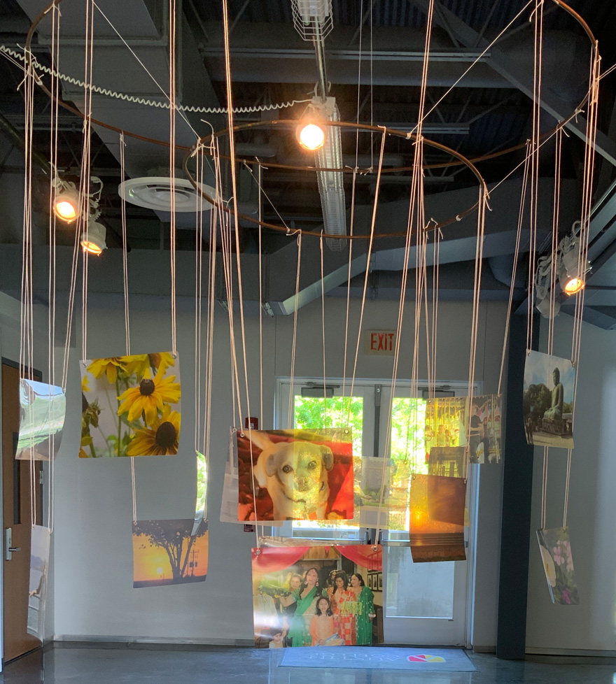 metal ring hanging from ceiling with photos hanging from string