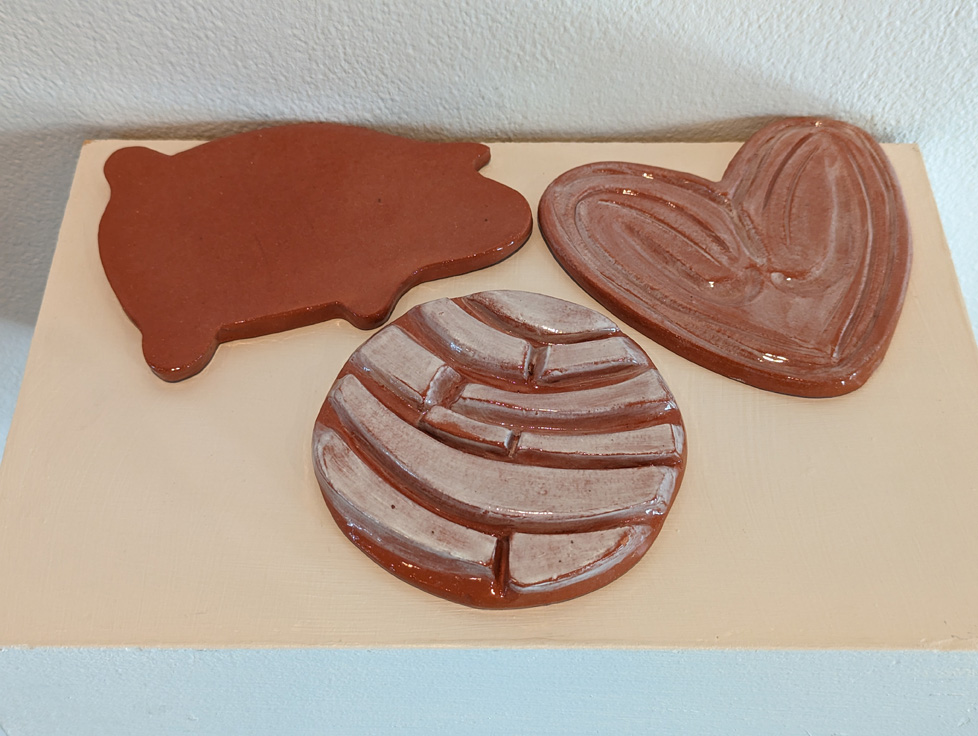 three ceramic coasters made to look like Mexican baked goods