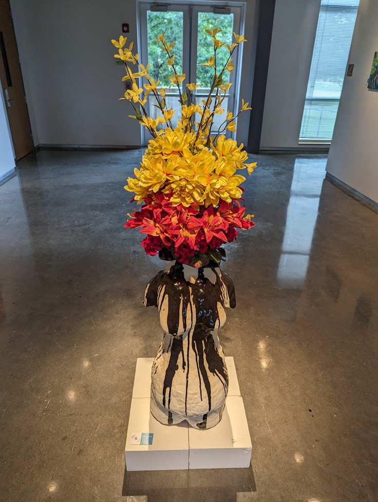 large vase with flowers, in the shape of human torso