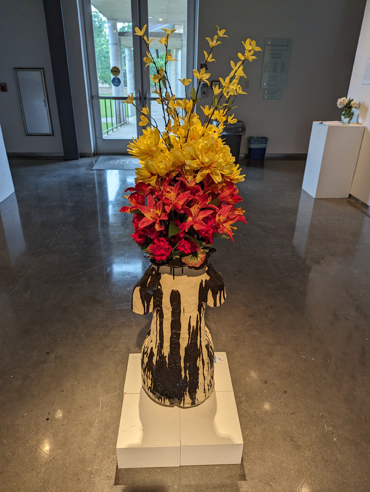 large vase with flowers, in the shape of human torso