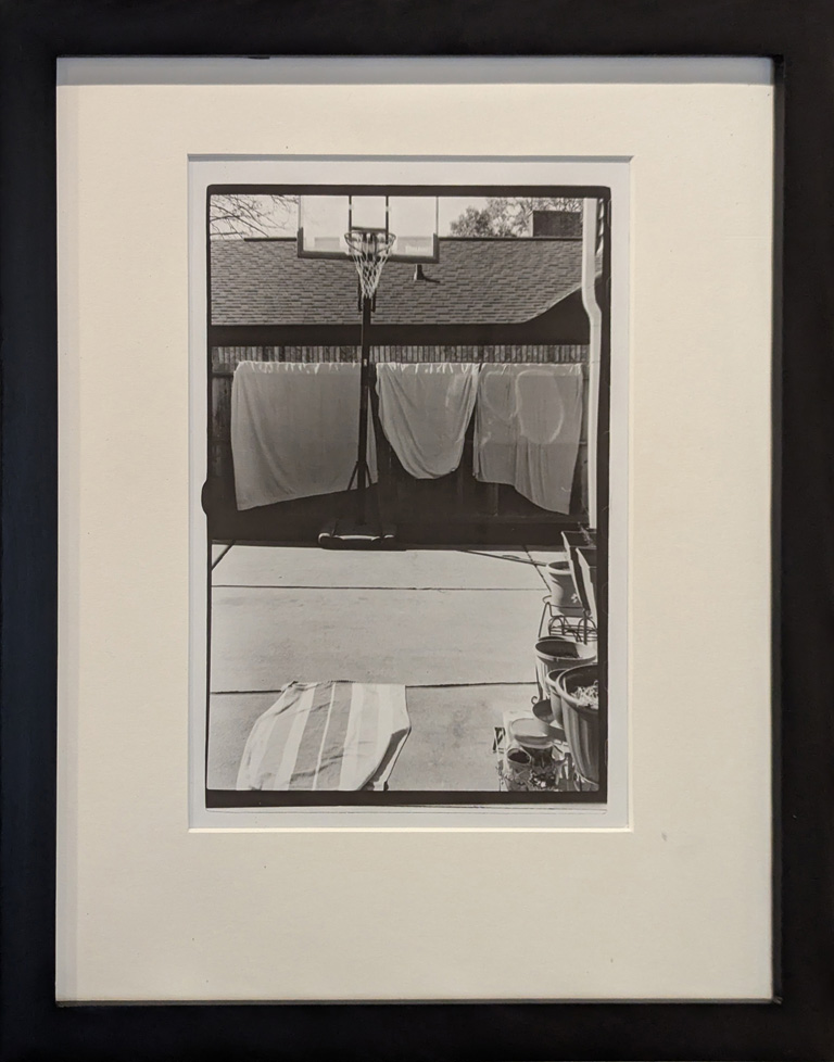 b/w photo of towles draped on suburban fence