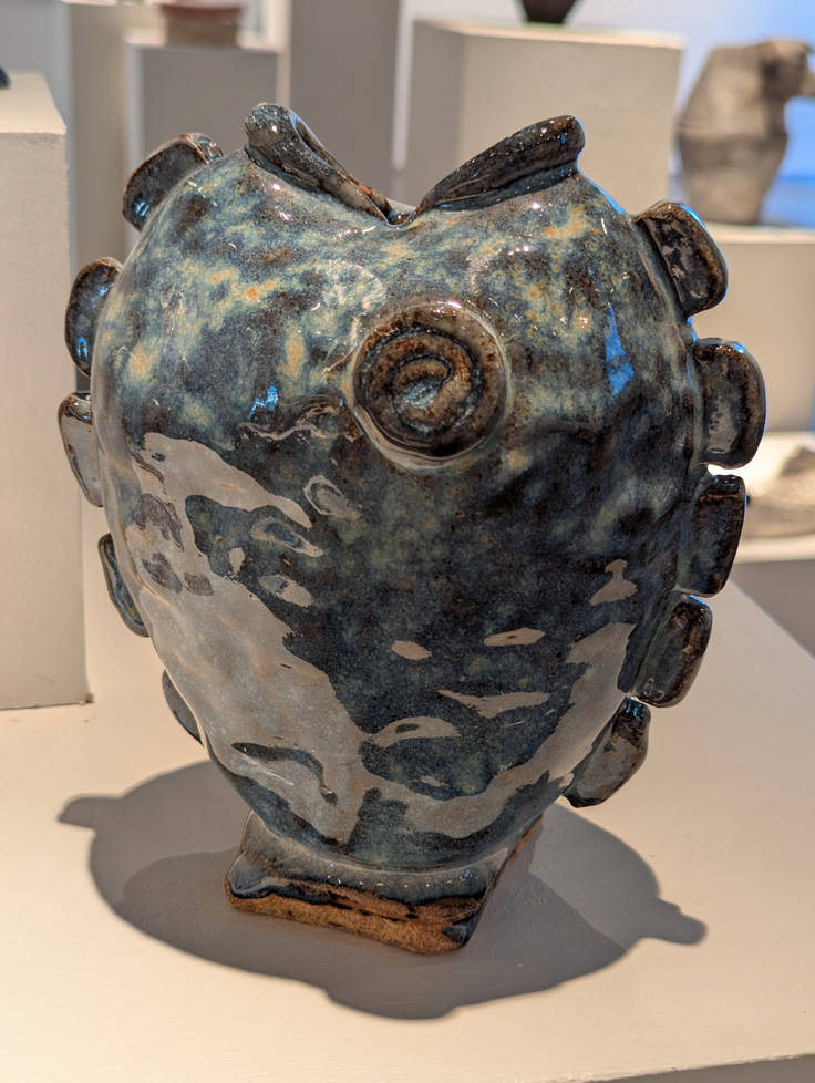 ceramic vase shaped like fish head where mouth is the opening