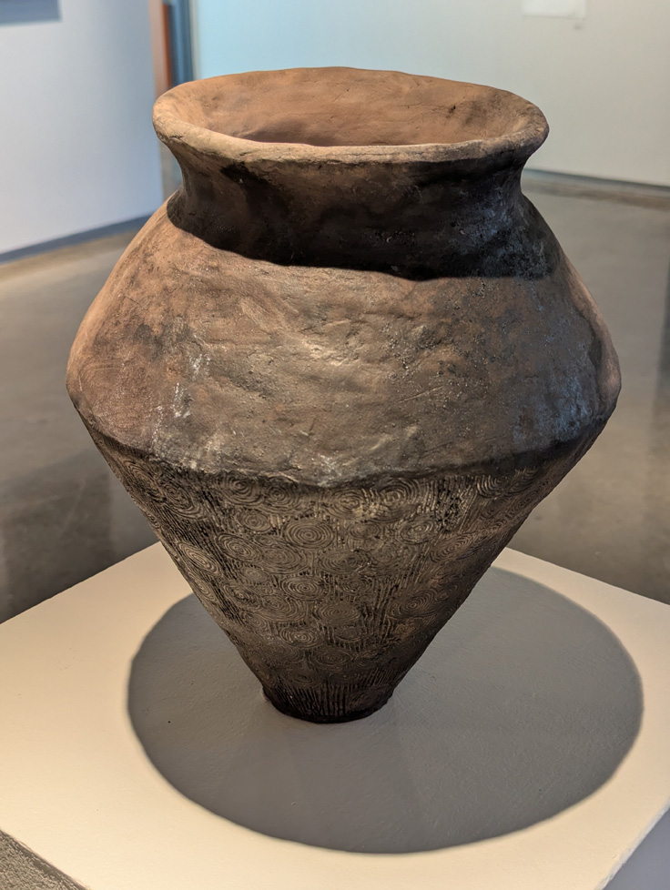 large, angular, brown vase with swirls on bottom half