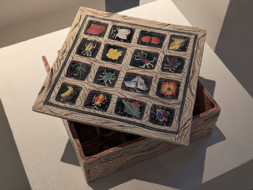 reliquary box for insects, ceramic with faux wood texture and images of bugs on lid