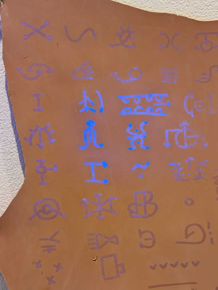 detail of symbols lit by flashlight, glowing blue