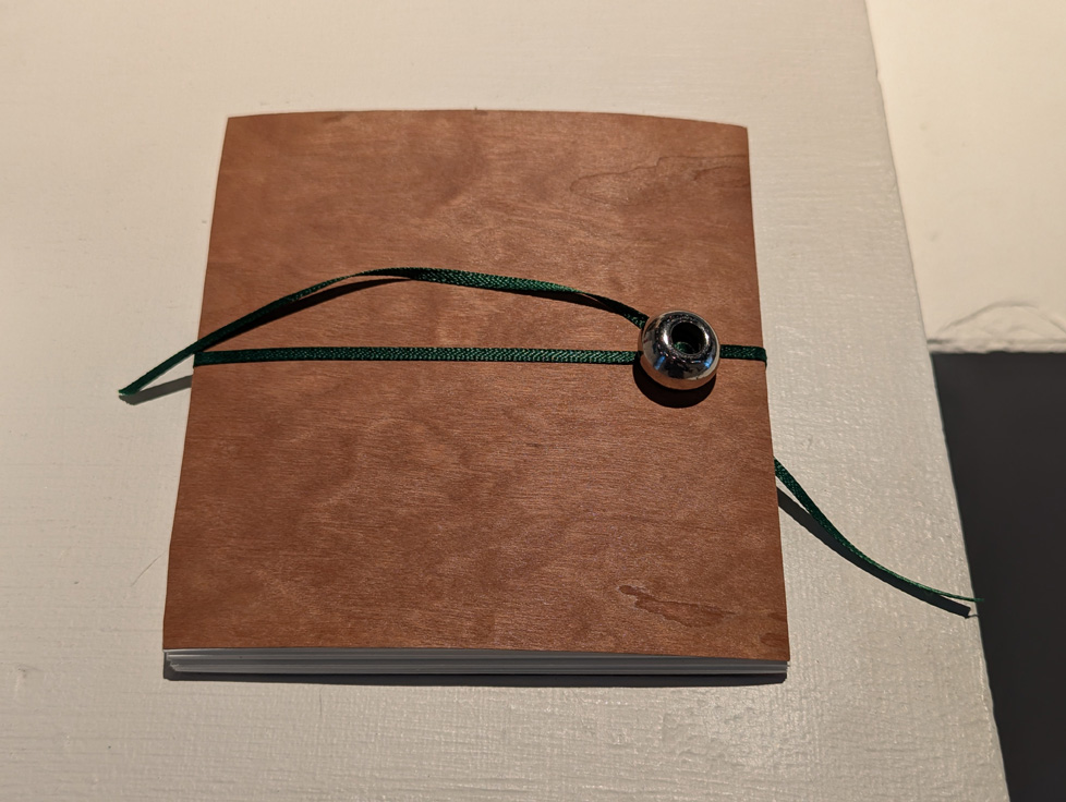 artist book: wood cover tied with a ribbon and bead