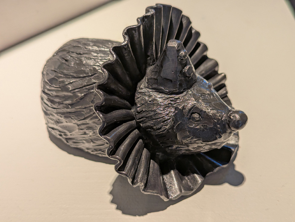 cast iron sculpture of small animal in clown outfit