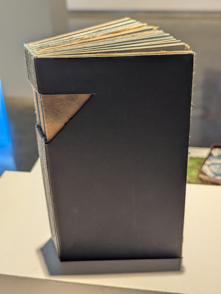 blue book with triangular window in cover and spine