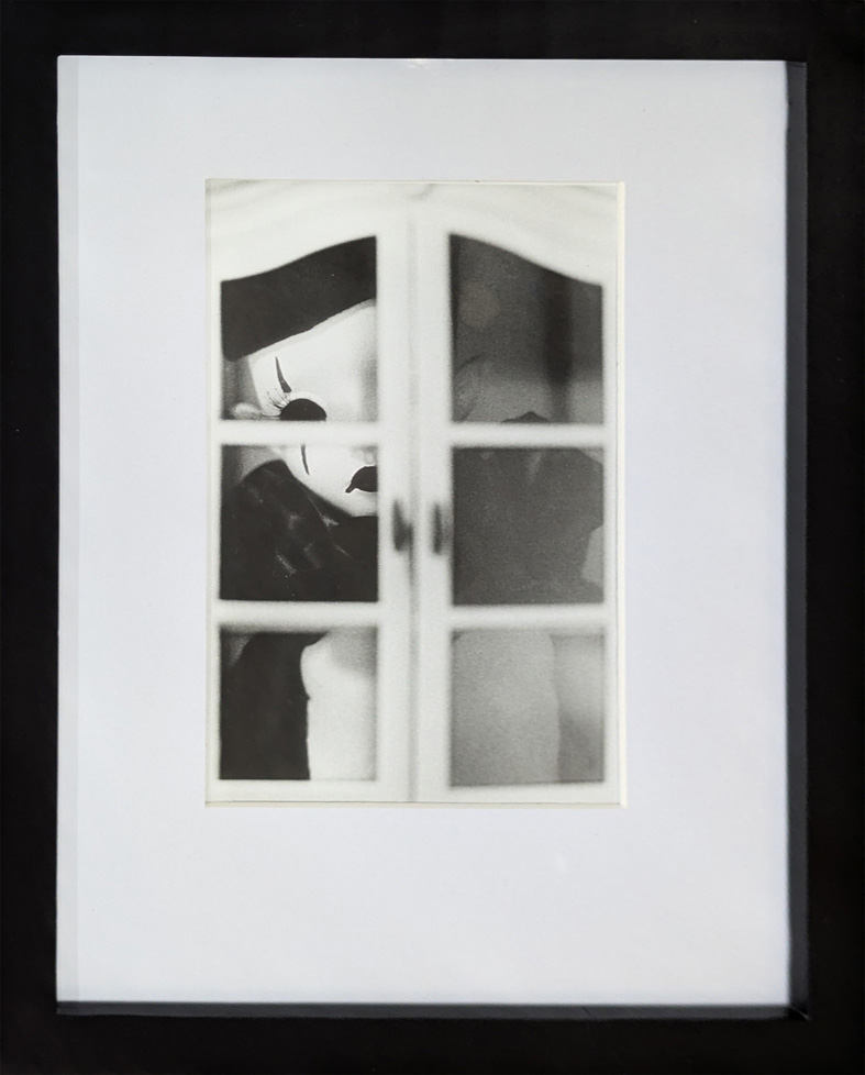 b/w photo of doll looking through window