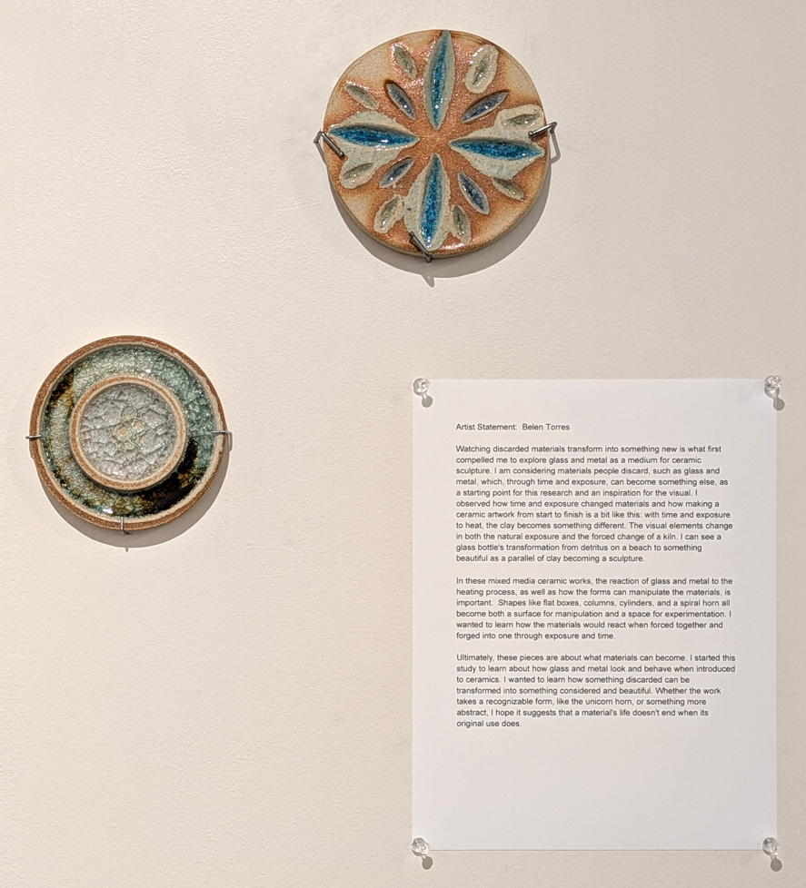 2 ceramic discs on wall with artist statment