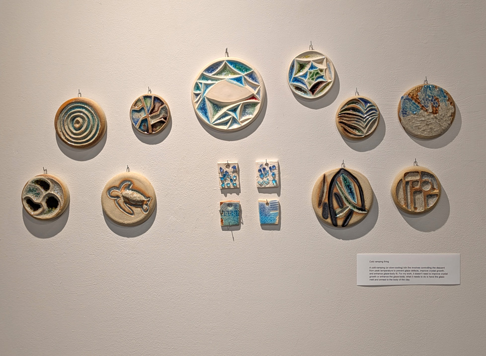 display of 10 ceramic discs and 4 tiles on wall