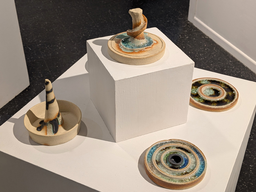 cluster of ceramics on pedestal: discs, some with central protrusions