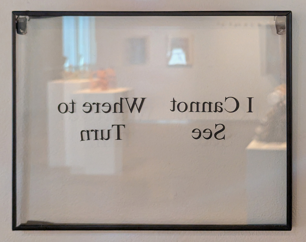 detail of installation: words printed mirrored on glass