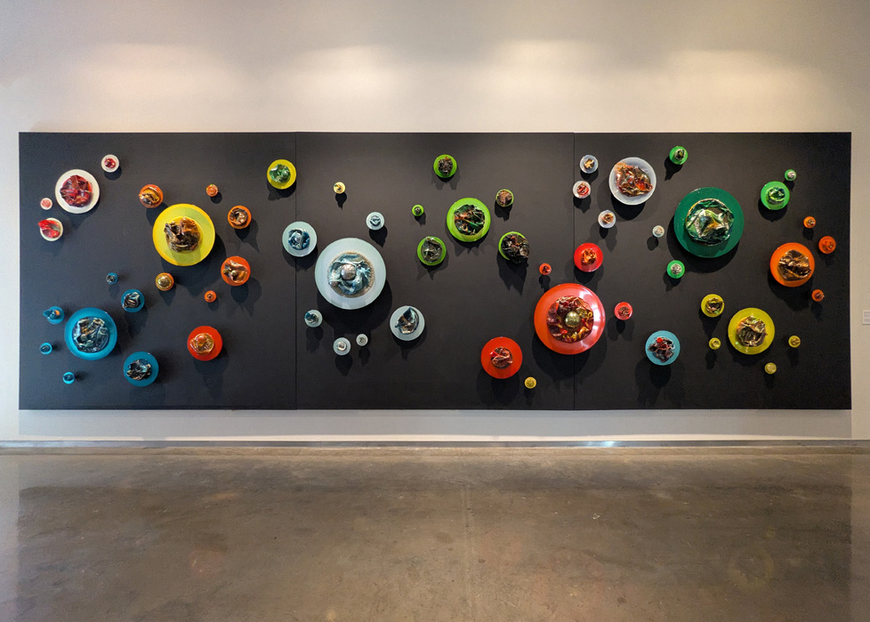 large sculptural wall mural, black canvas with colorful circles