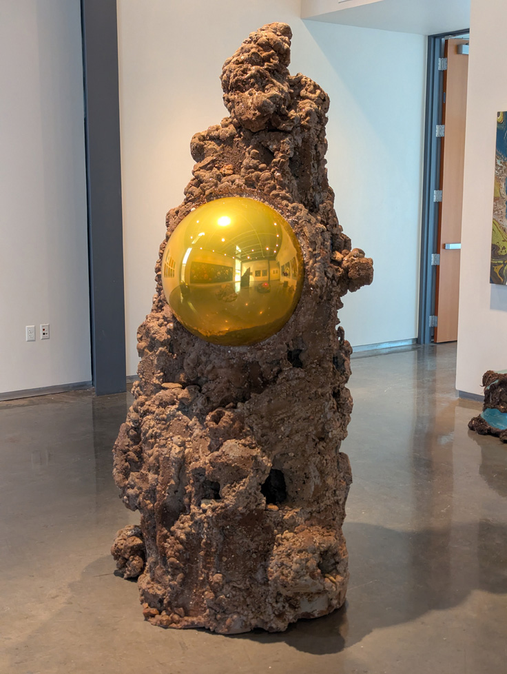 large floor standing sculpture, rock-like with yellow mirror balls