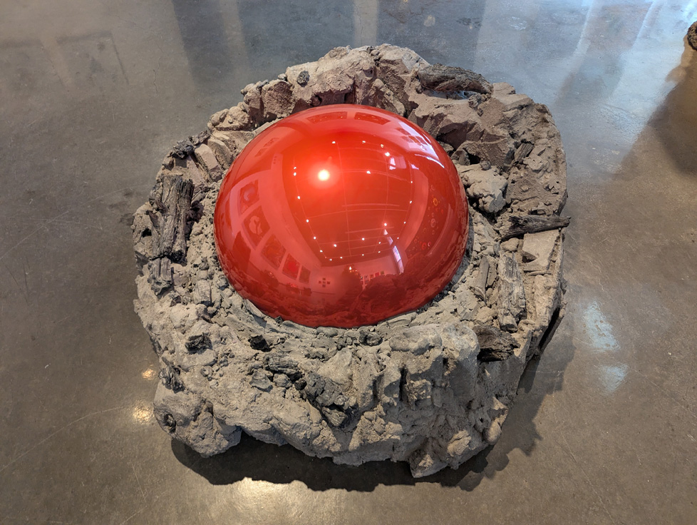 rock sculpture with red mirror ball